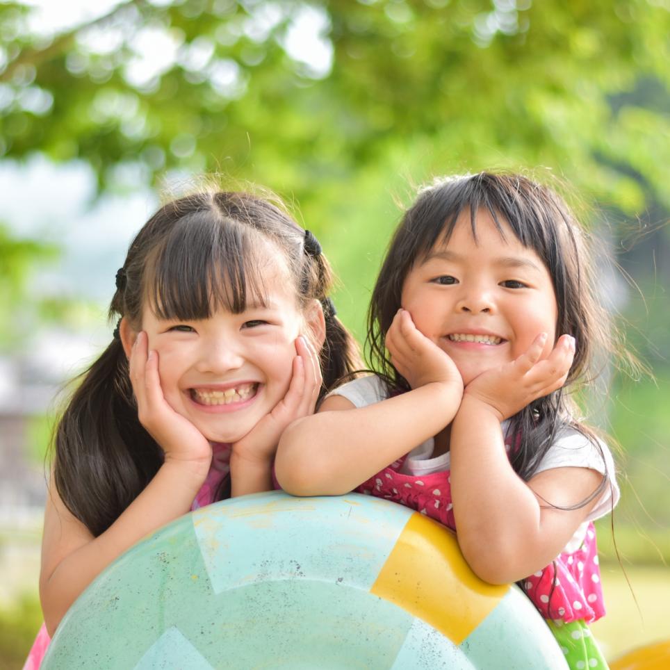2人の子供が笑顔でこちらを見ているの写真