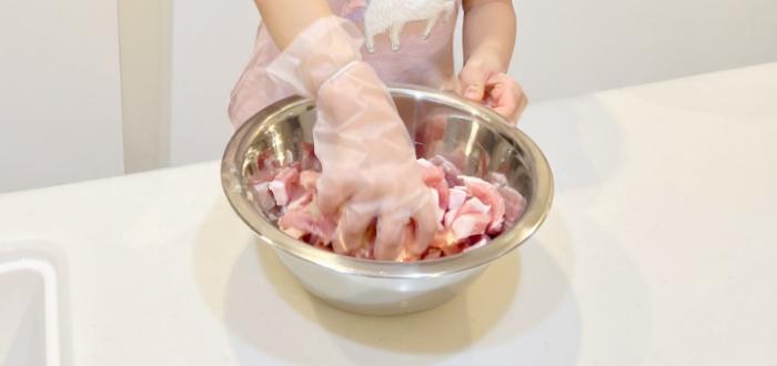 子供がボウルで料理の食材を混ぜている写真