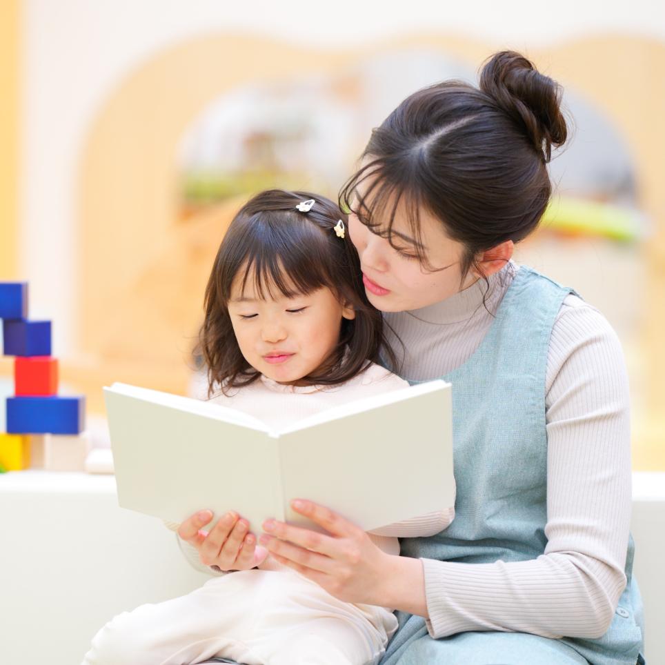 母親が子供に本を読んであげている写真
